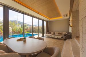 a living room with a table and chairs and a pool at Leaf Villa Terra in Antalya