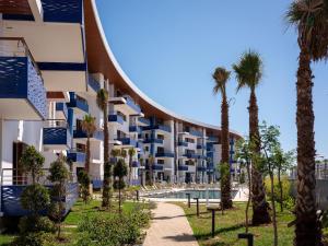 a resort with palm trees and a swimming pool at Zephyr Martil in Martil