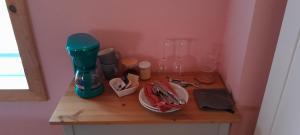 a wooden table with a coffee maker and glasses on it at La Reine in St-Etienne de Bolton