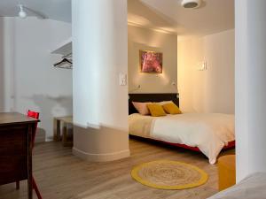 a bedroom with a bed with yellow pillows and a desk at Gîte de groupe et charmant cottage L'Agnel in Domaize
