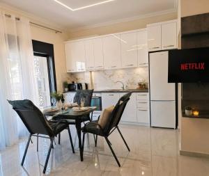 a kitchen with a table and chairs in a kitchen at Marine Apartment in Nea Peramos