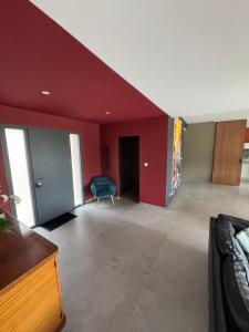 a living room with red walls and a blue chair at Villa à Lux in Lux