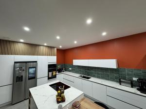 a kitchen with white cabinets and a red wall at Villa à Lux in Lux