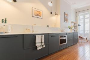a kitchen with gray cabinets and a sink at Luxueux Appartement - Hyper Centre - Climatisation - Balcon in Bordeaux +27 photos