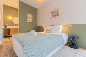 a bedroom with a large white bed and a bathroom at Luxueux Appartement - Hyper Centre - Climatisation - Balcon in Bordeaux