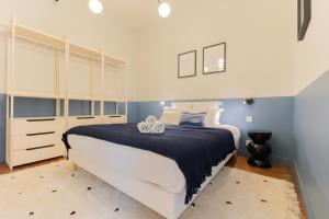 a bedroom with a large white bed and blue walls at Luxueux Appartement - Hyper Centre - Climatisation - Balcon in Bordeaux