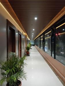 a hallway with potted plants in a building at hotel sunfire in Chhindwāra