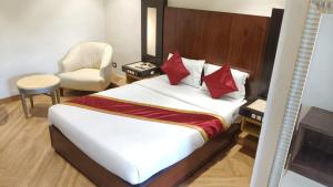 a bedroom with a bed with a chair and a desk at hotel sunfire in Chhindwāra