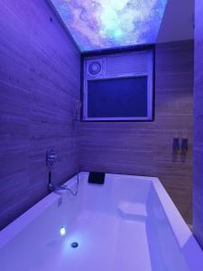a large white bath tub in a room with a window at hotel sunfire in Chhindwāra
