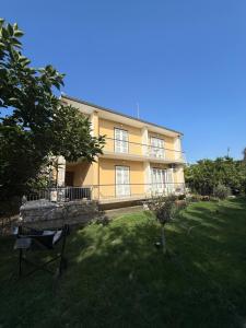 a large yellow house with a yard in front of it at Studio Apartmani ISRA in Palit