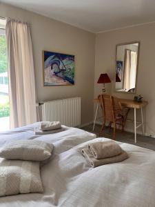 two beds in a bedroom with a desk and a chair at Fred og Ro Ferielejlighed in Ulstrup