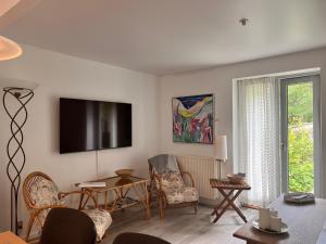 a living room with a flat screen tv on the wall at Fred og Ro Ferielejlighed in Ulstrup