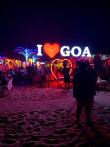 a group of people standing on a beach at night at Baga Beach Palm Cottage in Calangute