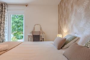 a bedroom with a large white bed with a window at L'évasion verte in Colroy-la-Roche