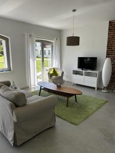 a living room with a couch and a coffee table at Ferienwohnung Alte Schmiede mit Gutspark in Rambin
