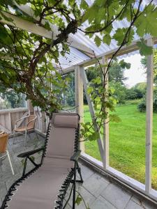 a chair on a patio with a pergola at Fred og Ro Ferielejlighed in Ulstrup