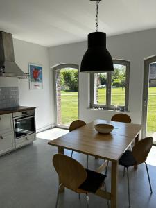 a kitchen with a wooden table and chairs and aendant light at Ferienwohnung Alte Schmiede mit Gutspark in Rambin