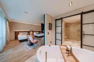 a bathroom with a bath tub and a bedroom at 1616 Hotel in Medellín