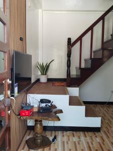 a living room with a table and a tv at Felrita Homestay in Alegria +6 photos