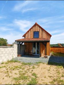 a large wooden house with a large window at Chrisme in Saint-Hilaire-Fontaine