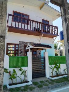a house with a balcony and a deck at Felrita Homestay in Alegria