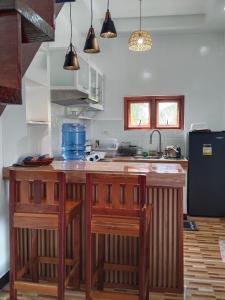 a kitchen with a wooden island with two stools at Felrita Homestay in Alegria