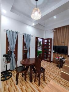 a dining room with a table and chairs and a television at Felrita Homestay in Alegria