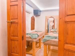 a bathroom with two beds and a mirror at Riad N'S & Spa in Marrakesh