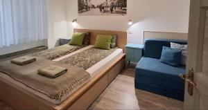 a bedroom with a bed and a blue couch at M37 Apartman in Debrecen