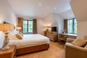 a bedroom with a bed and a desk and a chair at Villa Magdalena Eeklo in Eeklo