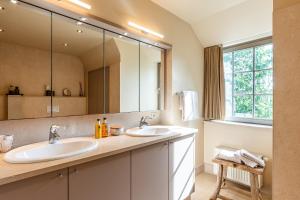 a bathroom with two sinks and a large mirror at Villa Magdalena Eeklo in Eeklo +122 photos