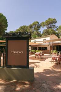 a sign in front of a building with tables and chairs at wecamp L'Escala Punta Milà in L'Escala