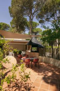 a patio with a table and chairs and an umbrella at wecamp L'Escala Punta Milà in L'Escala