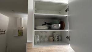 a white cabinet filled with dishes and vases at Le Fabuleux - 2 Guests in Dijon +9 photos