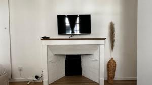 a living room with a fireplace with a tv above it at Le Fabuleux - 2 Guests in Dijon