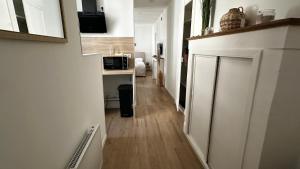 a hallway leading to a kitchen with a counter and a microwave at Le Fabuleux - 2 Guests in Dijon