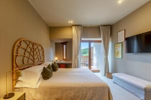 a bedroom with a large bed and a couch at Is Molas Resort in Pula +99 photos