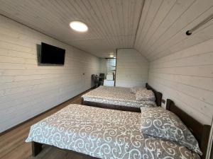 a room with two beds and a tv in it at Cottage v Gorakh in Izki