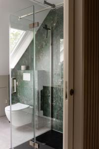 a glass shower in a bathroom with a toilet at Hannes in Schagen
