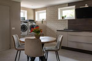 a kitchen with a table and chairs and a washing machine at Hannes in Schagen +29 photos