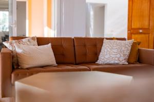 a brown couch with pillows in a living room at Villa Evita Private Pool, Jacuzzi & Sea views in Adeje +48 photos