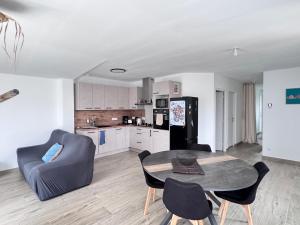 a living room with a table and chairs and a kitchen at Ideal pour un couple in Saint-Georges-dʼOléron