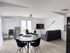 a living room with a table and chairs at Ideal pour un couple in Saint-Georges-dʼOléron +2 photos