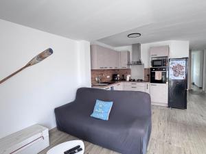 a living room with a couch and a kitchen at Ideal pour un couple in Saint-Georges-dʼOléron