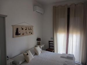 a white bedroom with a bed and a window at Le Porte del Sole in Girasole