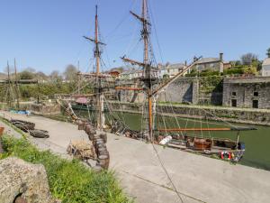 a tall ship docked in a river next to a building at Treetops in Par