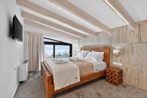 a bedroom with a large bed and a television at September15 Boutique Suites - Nikiana in Nikiana +205 photos