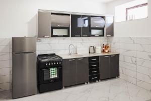 a kitchen with a stove and a refrigerator at Dea Apartments - Peja in Peje