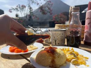 a person is drizzling sauce onto a plate of food at EcoFunco in Portela