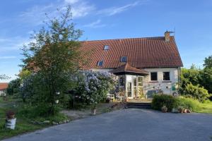 a large white house with a red roof at Kulturgutleben in Möllenbeck
